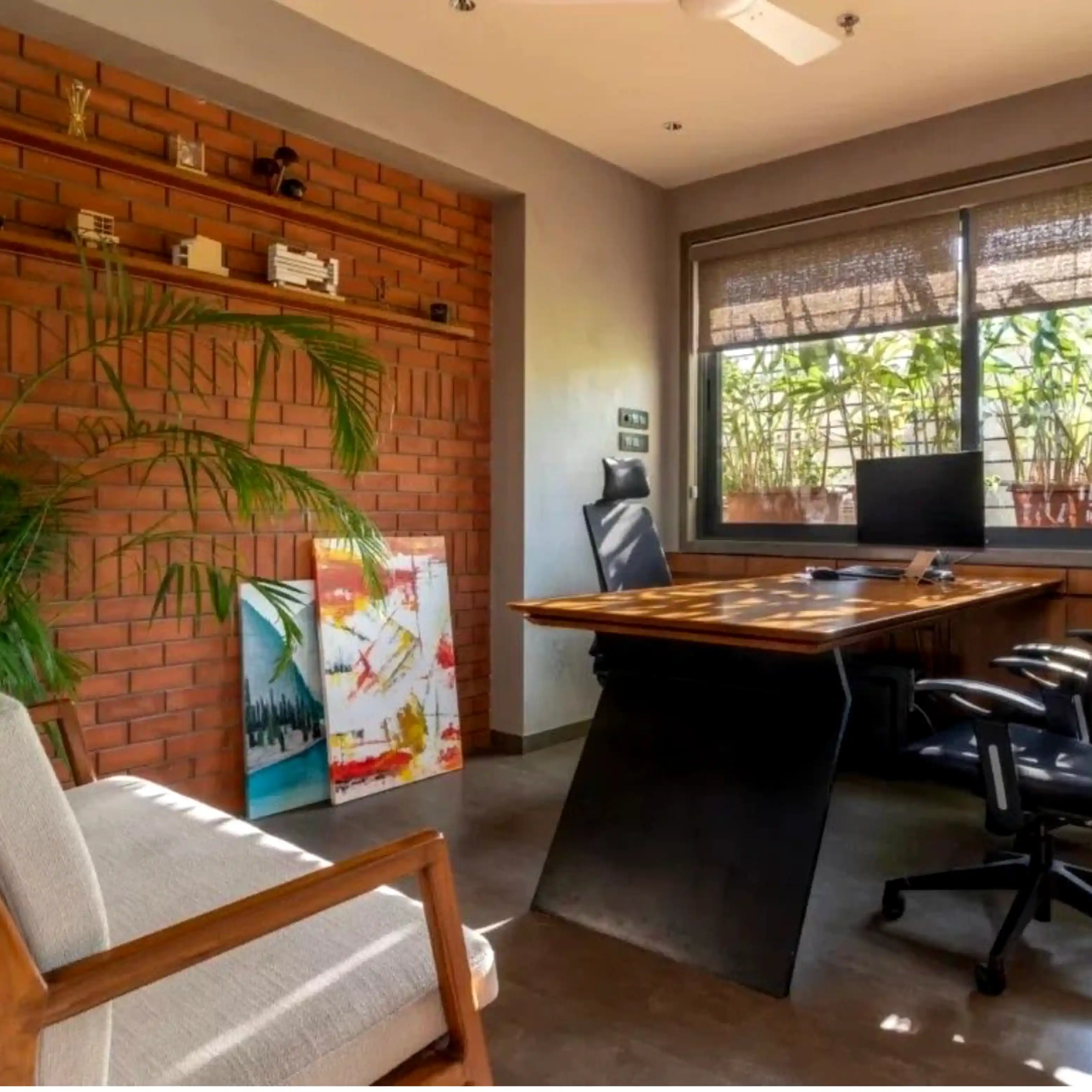 Flowrush office studio with brick wall, wooden desk, plants, and natural light